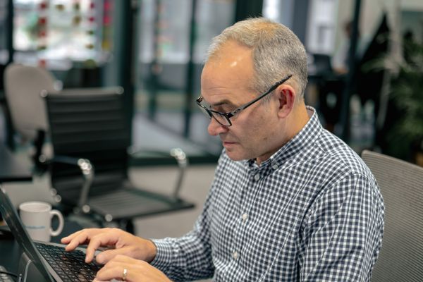 CEO examining strategies for ethical hacking and its business advantages on a laptop