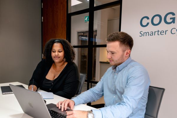 Two cyber security experts discussing red vs blue team exercises during a meeting