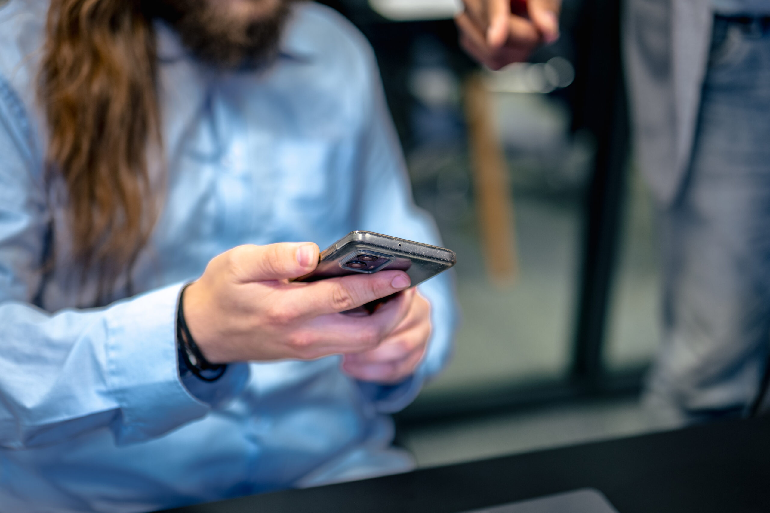 Employee holding a smartphone for evaluation in mobile application testing