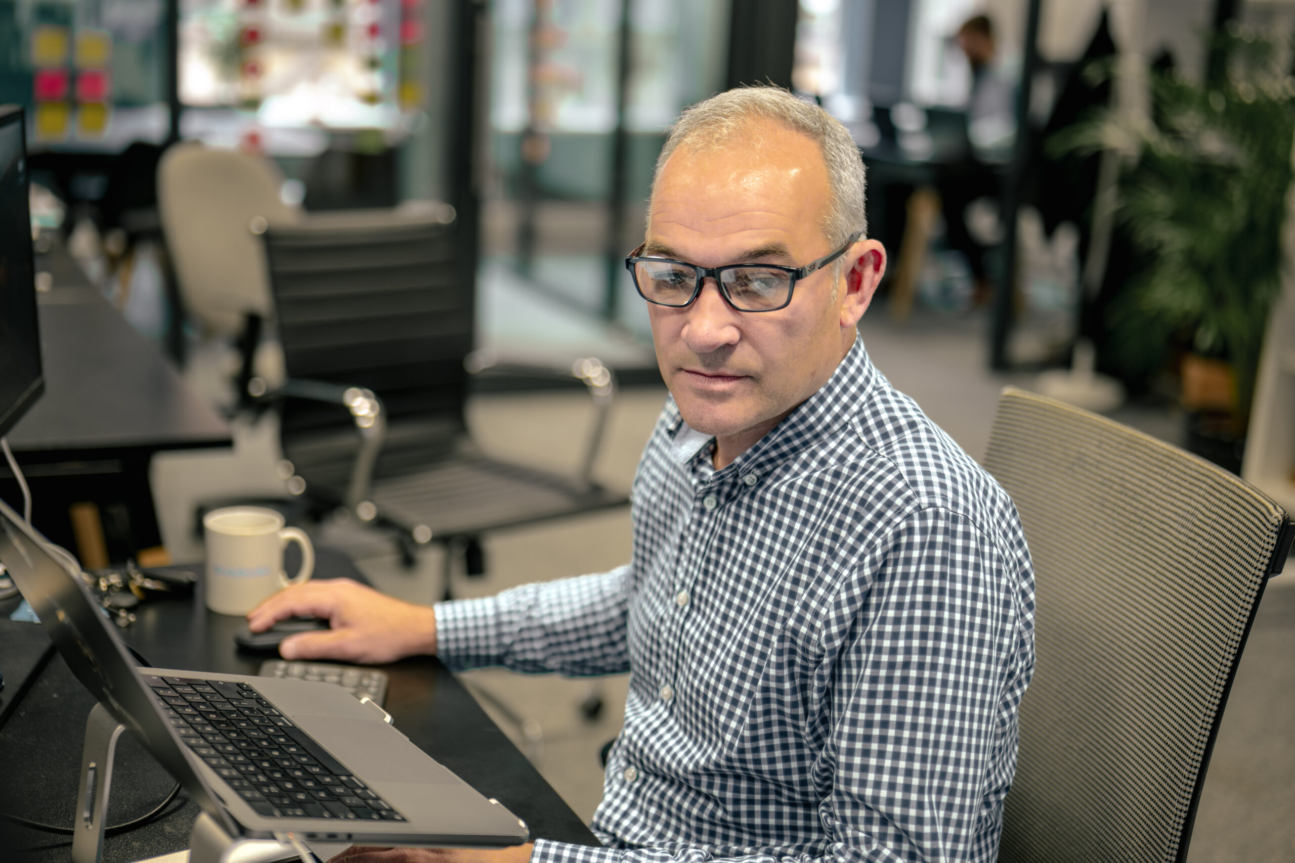 Cyber security consultant working on his laptop, conducting an Assumed Breach Assessment to test internal security measures and response capabilities.