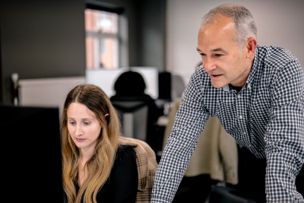 Two vCISOs collaborating on policy review to strengthen client compliance and security strategies